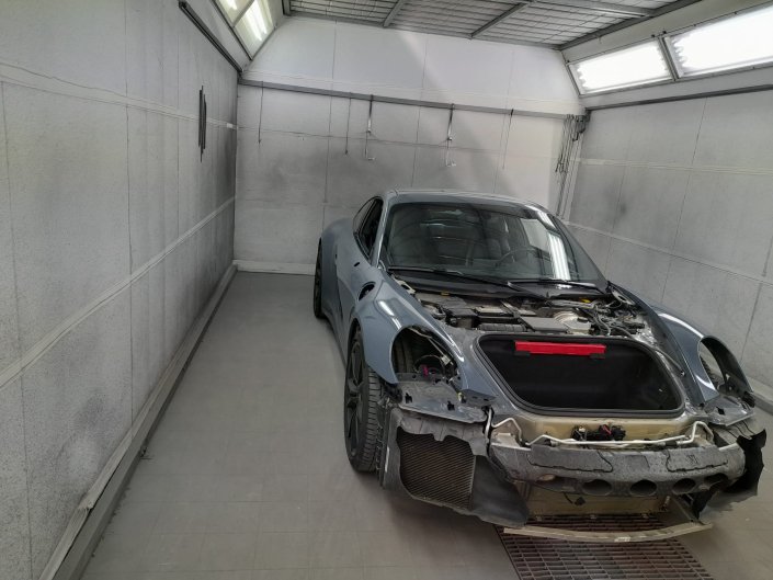 Originalaufnahme aus der Maia-2-Galerie: teilweise demontierter Porsche in einer Lackierkabine